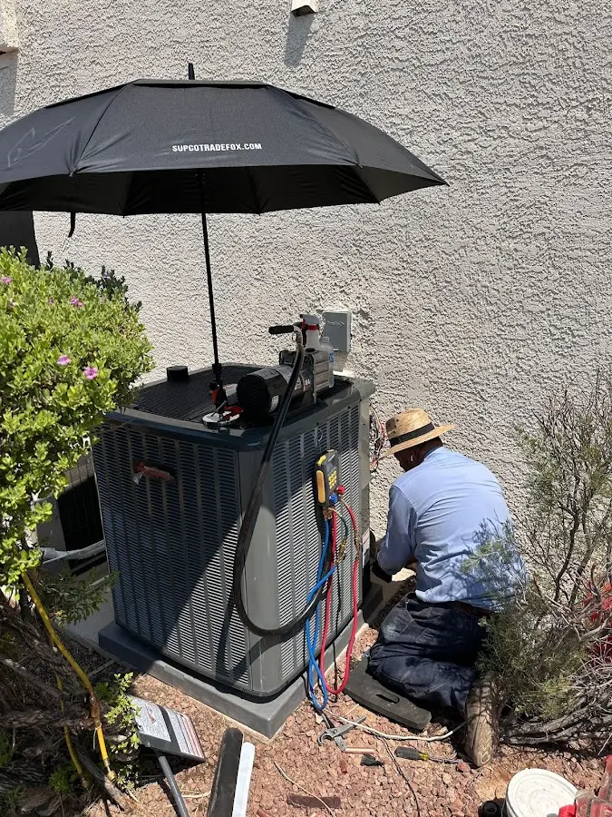 HVAC technician performing outdoor AC maintenance in Mecca